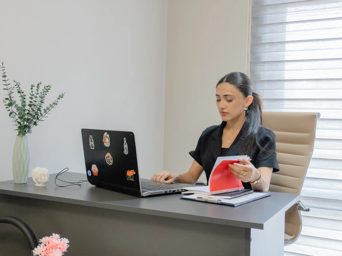 Asesora trabajando con el portátil y documentos en su despacho